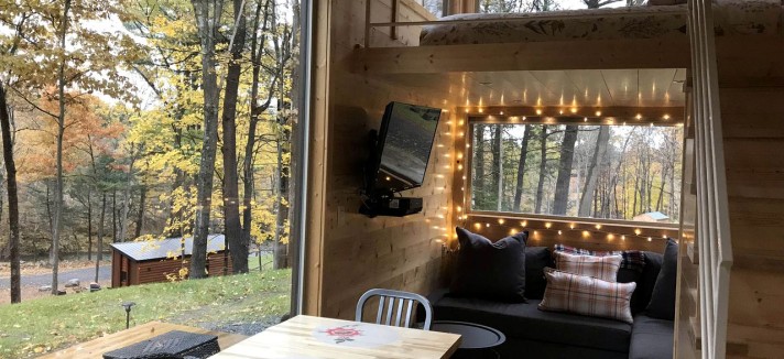 Sala de estar e uma cama 'lá em cima'