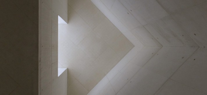 Las aberturas en la torre y el tejado permiten la entrada de luz natural, creando un juego de luces y sombras que enriquece la experiencia espacial y espiritual de los visitantes.