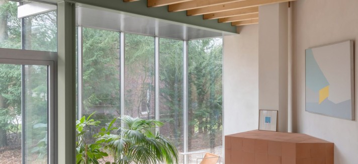La planta baja cuenta con amplias superficies acristaladas que enmarcan las vistas hacia los árboles exteriores