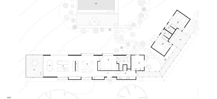 El diseño responde a una configuración en forma de L, formada por dos alas diferenciadas conectadas por una pasarela exterior cubierta.