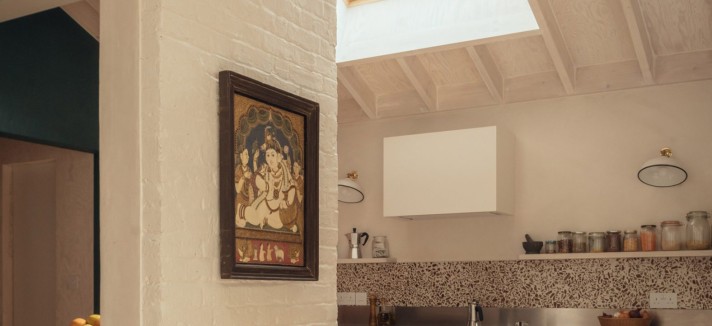 En la nueva cocina, los techos de contrachapado dialogan con los muros de ladrillo pintados de blanco de la casa original.