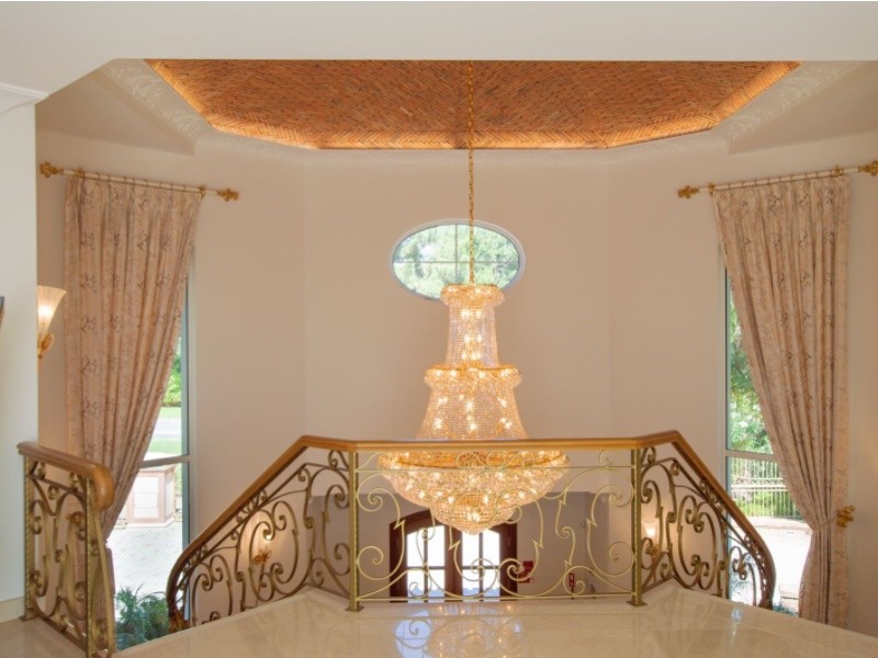 The property welcomes you in style with a double staircase and chandelier