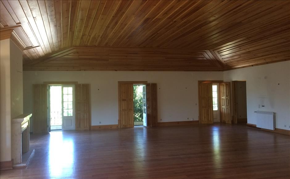 The property has large, open spaces with real wood ceilings and floors