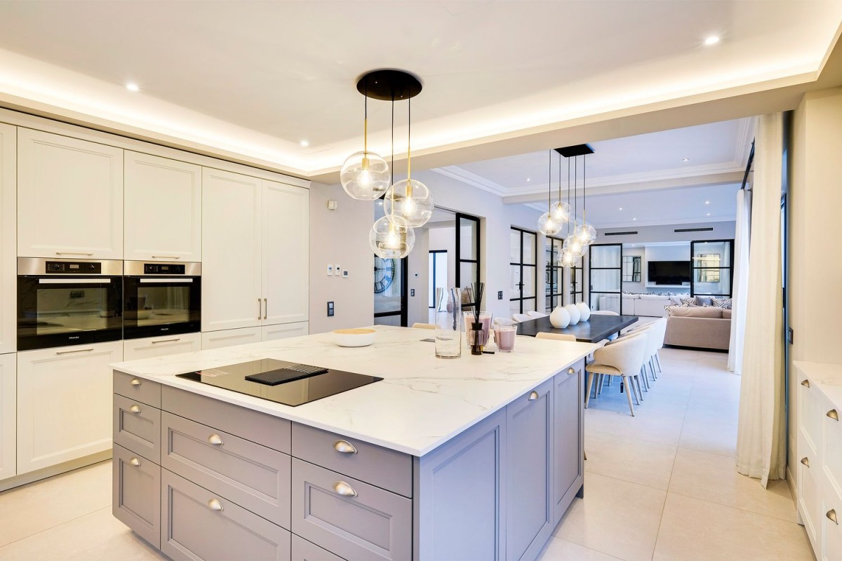 The kitchen is modern and open, connecting to the dining room and living area