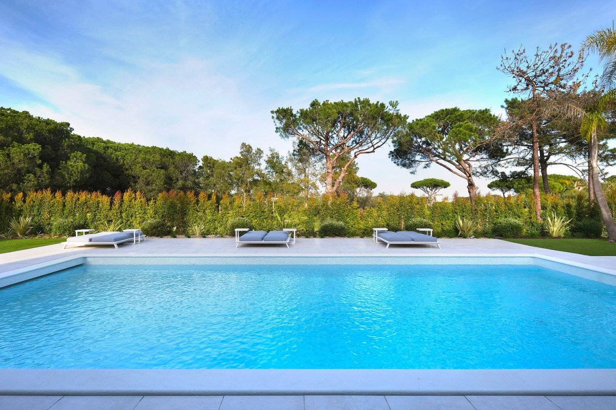 The villa is surrounded by a beautiful garden and large pool