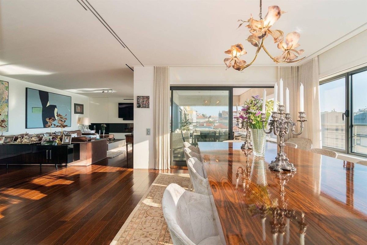 The living room is connected to a stunning dining area with terrace access