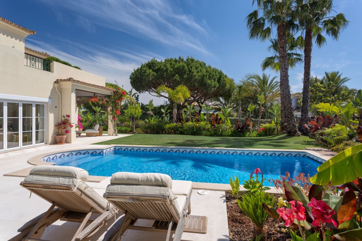 The villa is surrounded by a beautiful garden and pool