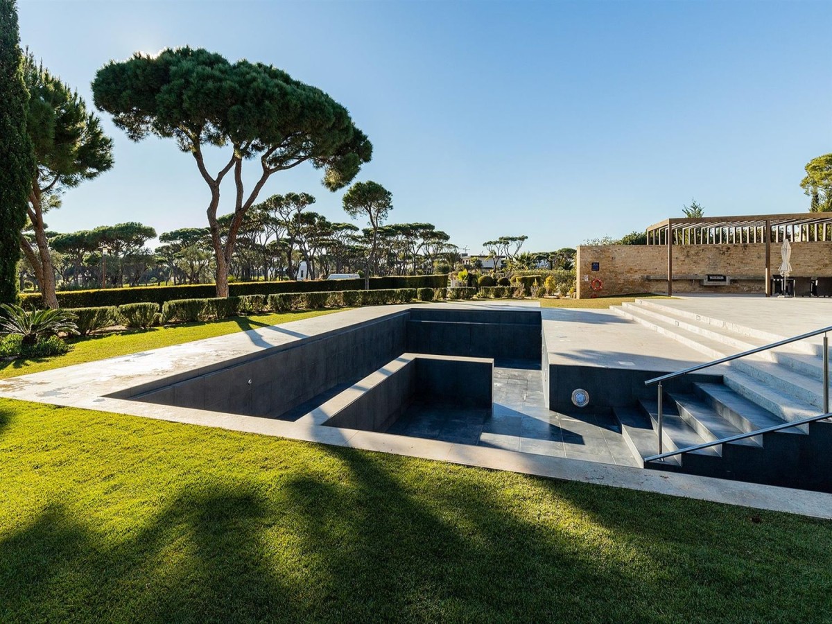 The villa has a spacious garden with a large pool