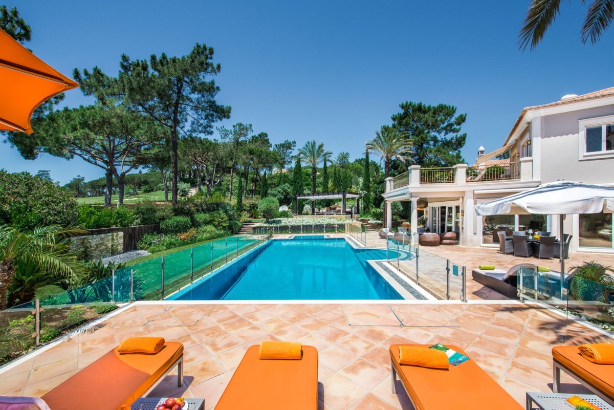 The villa has a spacious garden with a large pool