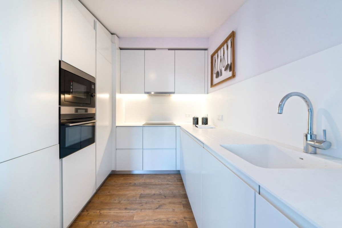 The fully equipped kitchen is modern and bright