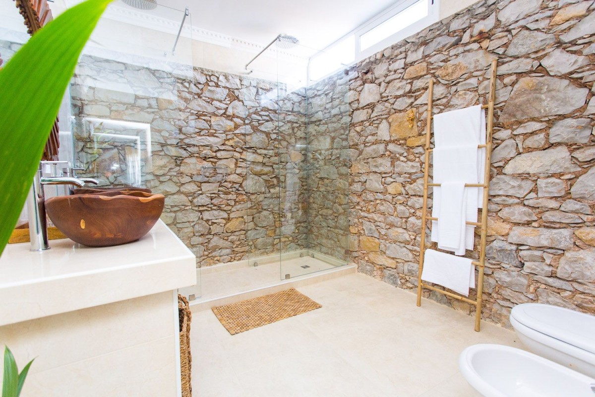 La pietra in questo splendido bagno è una delle caratteristiche top di questa proprietà