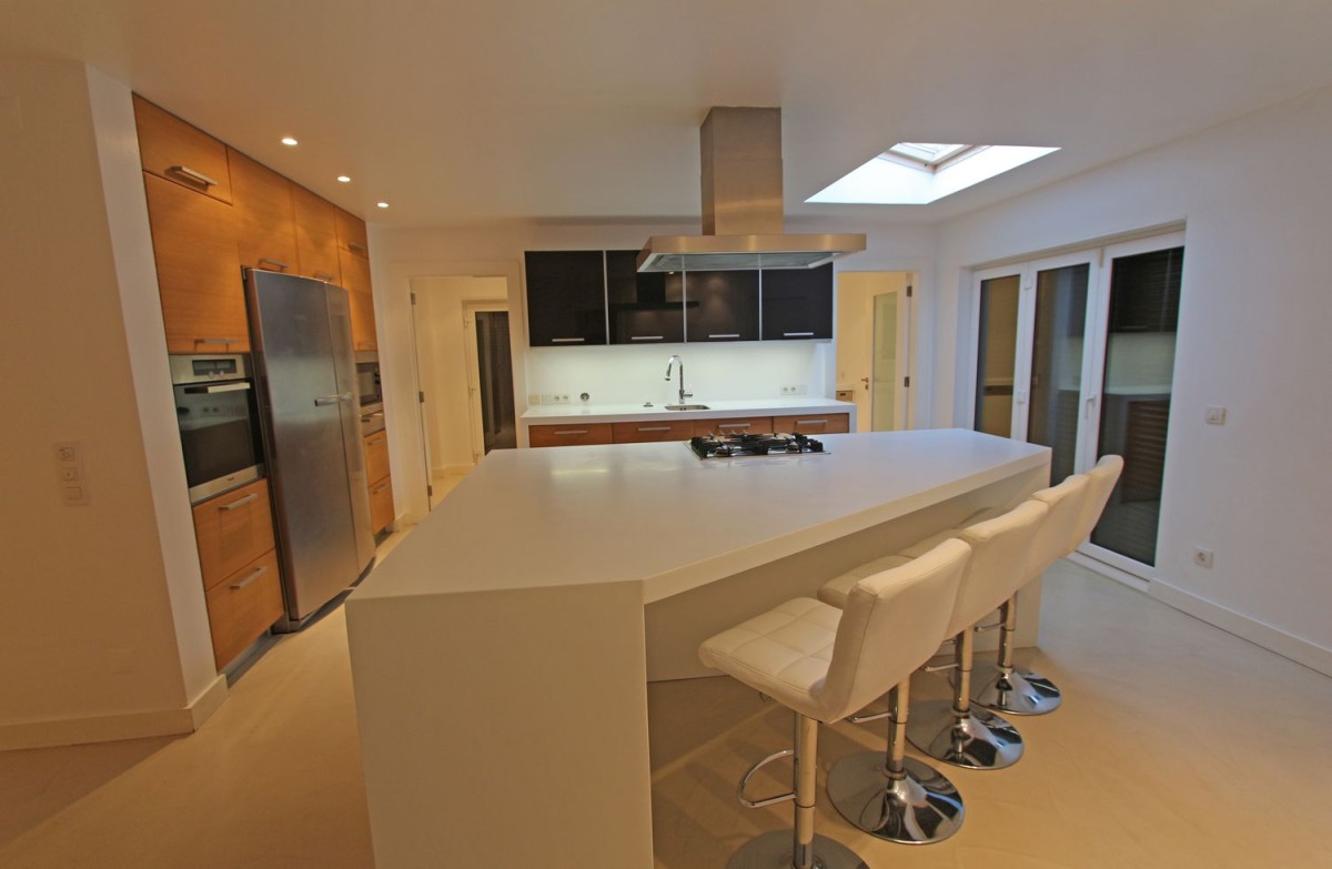 The kitchen elegantly uses the oddly shaped space it occupies