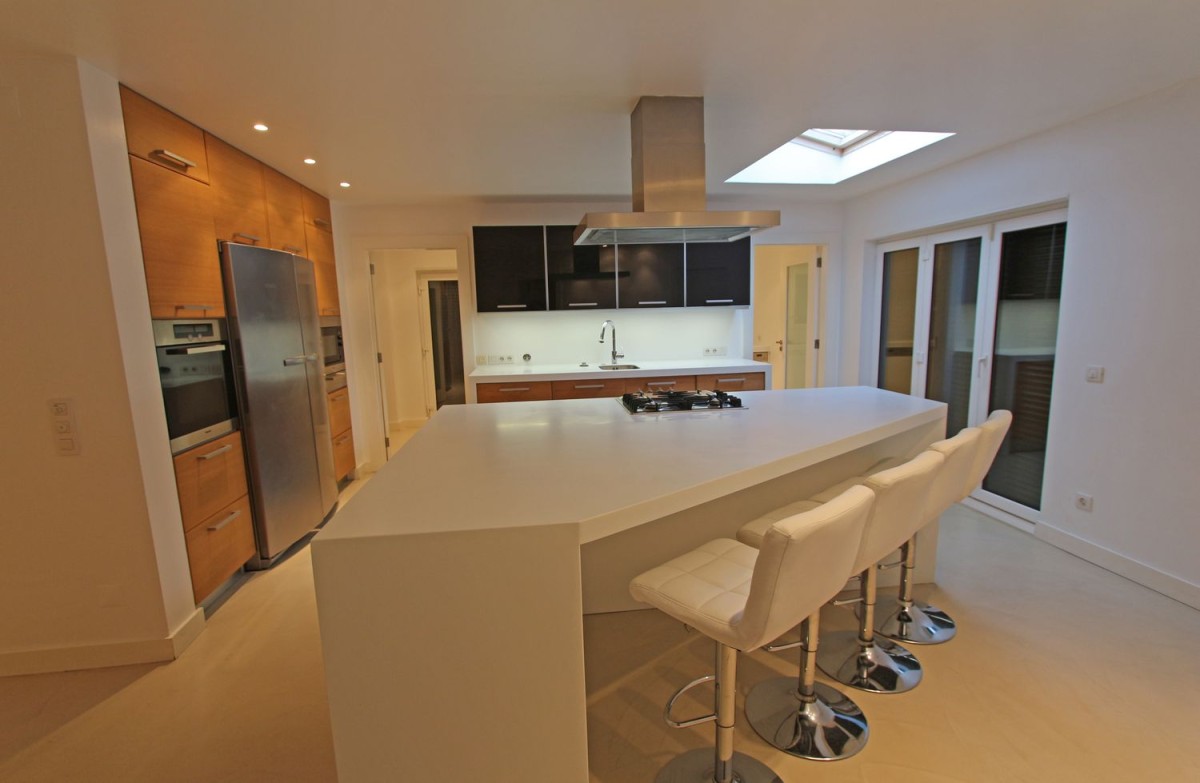 The kitchen elegantly uses the oddly shaped space it occupies