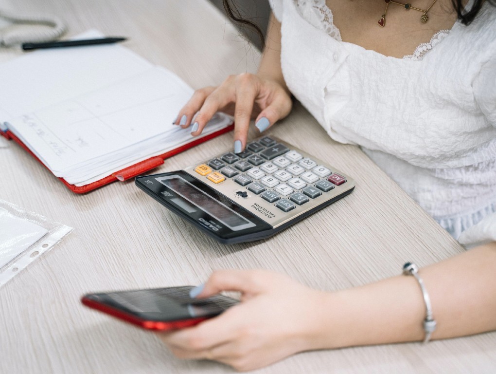 Mulher a fazer contas na calculadora
