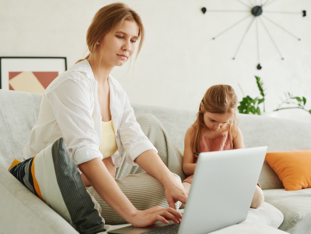 Mulher no computador com filha