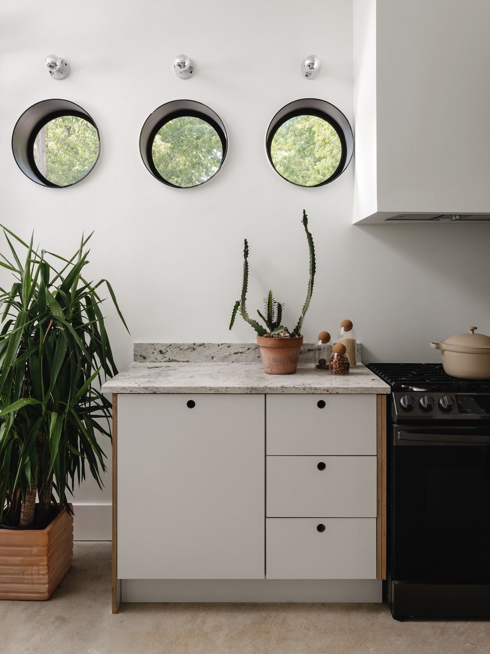 Cozinha pequena com janelas circulares e eletrotrodomésticos