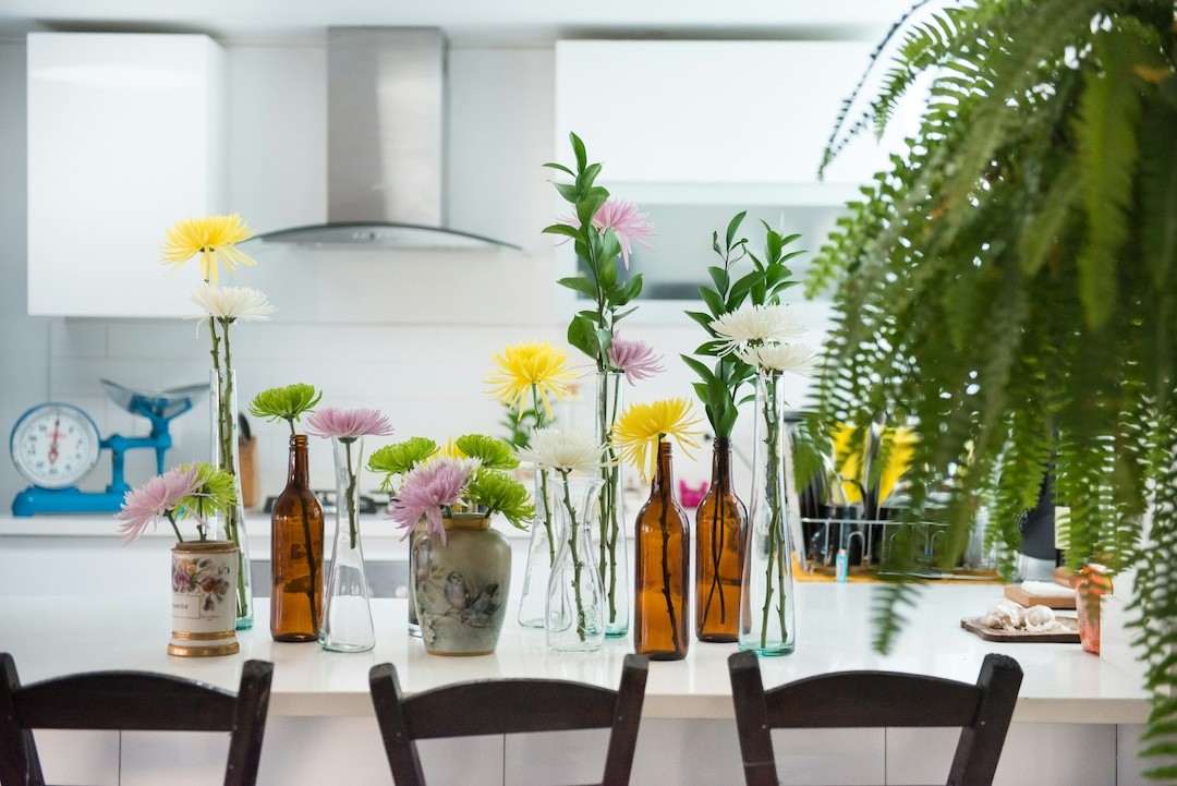 decoração da mesa com flores em garrafas de vidro