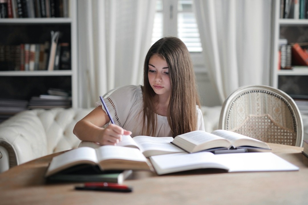 criança a estudar com manuais