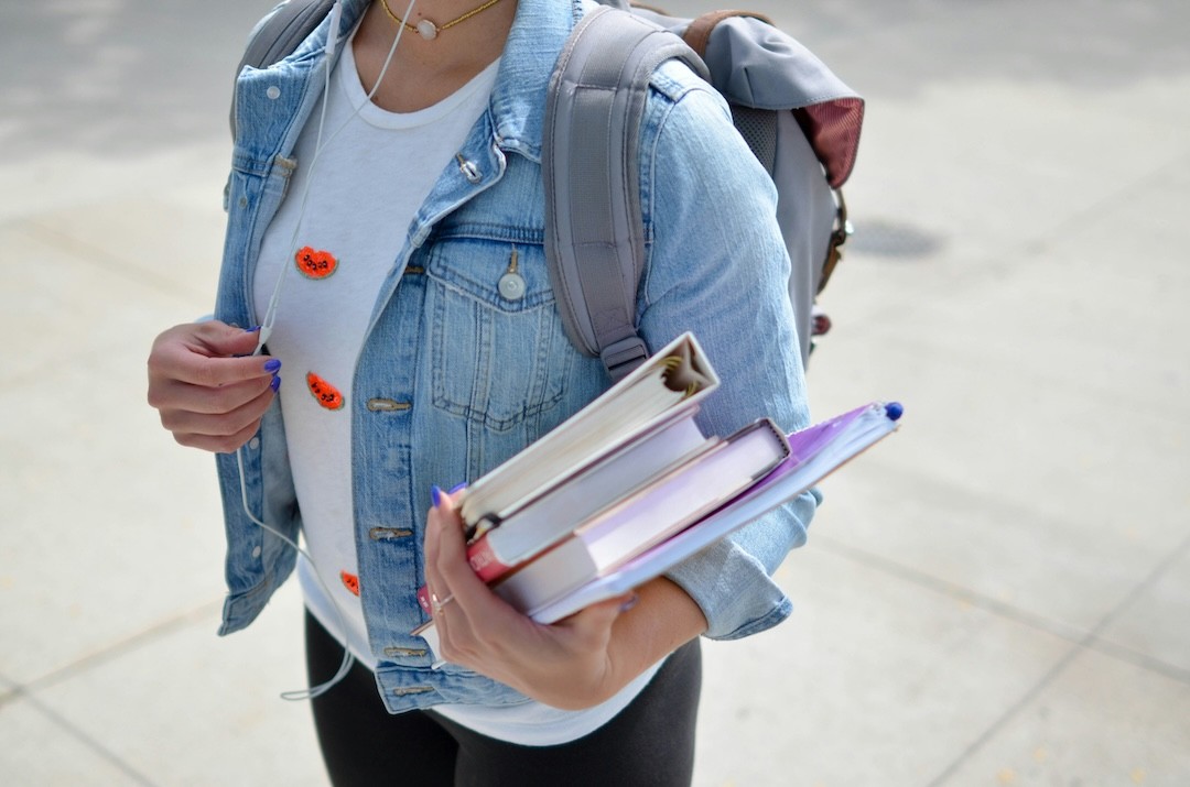 jovem com manuais escolares na mão