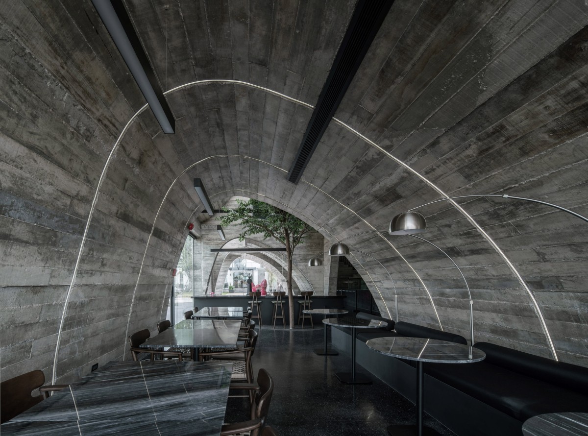 O atelier aproveitou a forma curvilínea de um croissant para estruturar o interior da pastelaria, criando arcos de formas irregulares que proporcionam dinamismo visual ao espaço.
