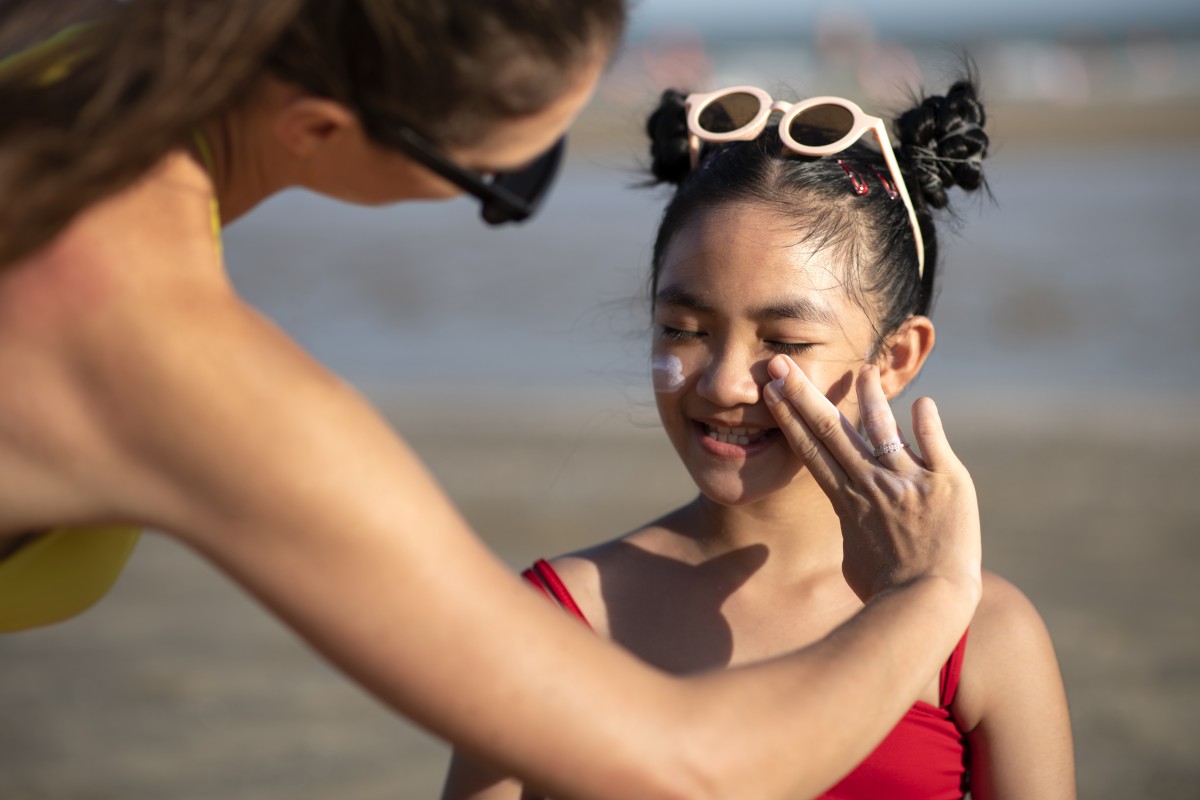 Mãe coloca protetor solar facial na criança