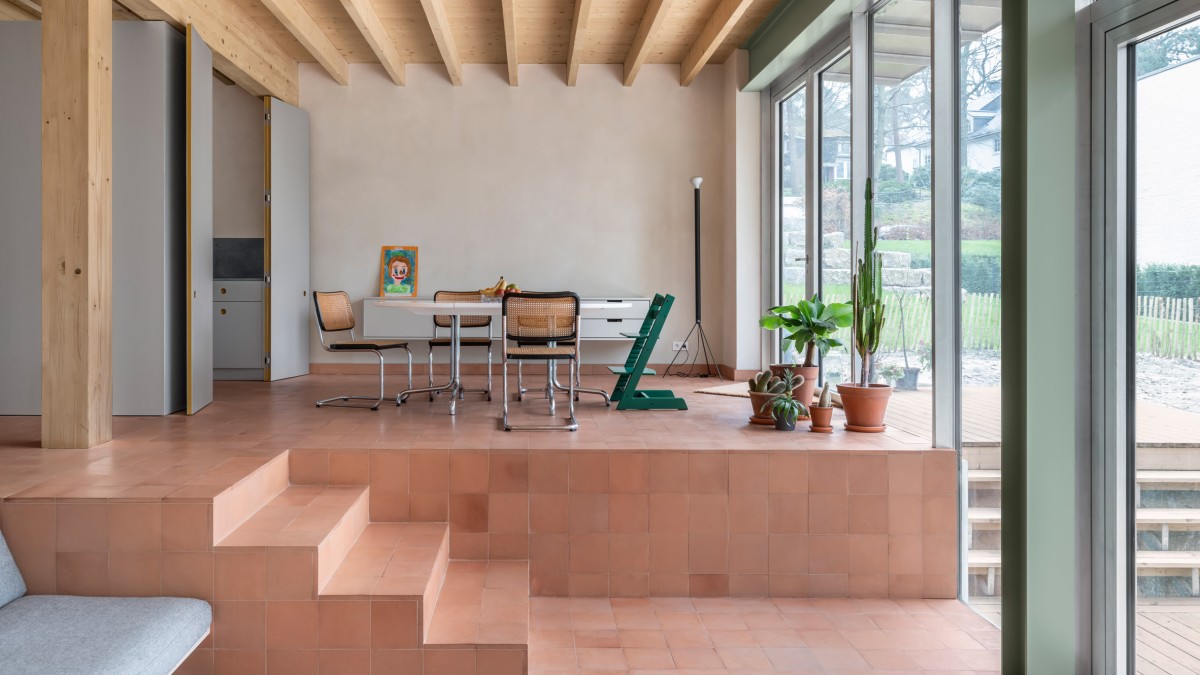 La planta baja se adapta al terreno natural con dos niveles conectados por una serie de escalones.