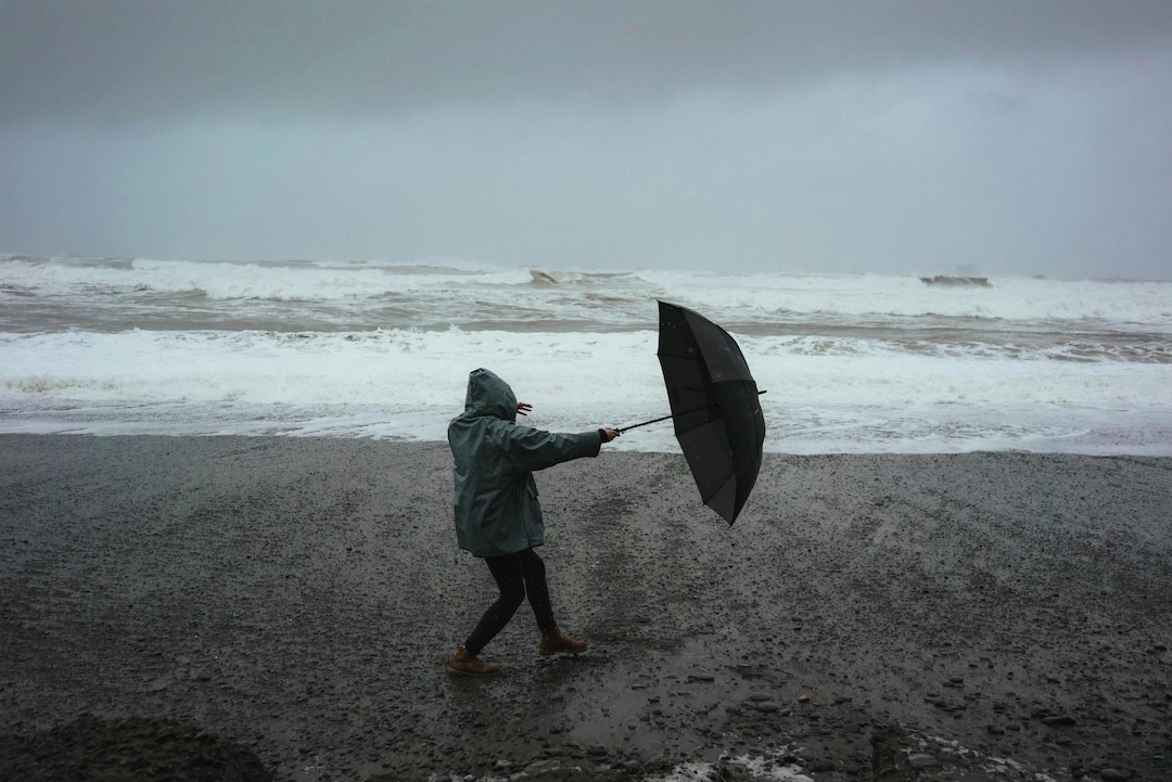 trausente com guarda chuva na praia
