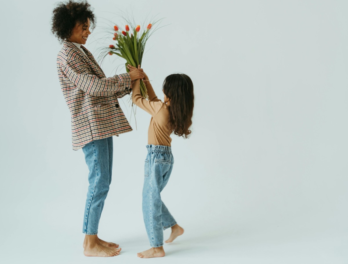 criança a entregar flores à mãe