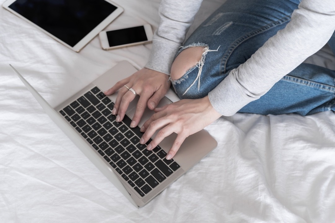 mulher a usar o computador na cama