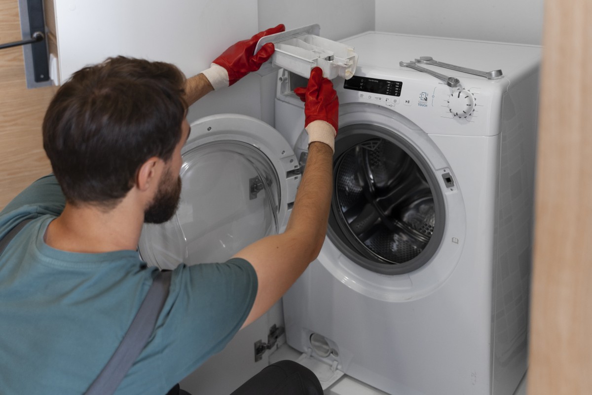 Senhor a limpar o filtro da maquina de lavar roupa