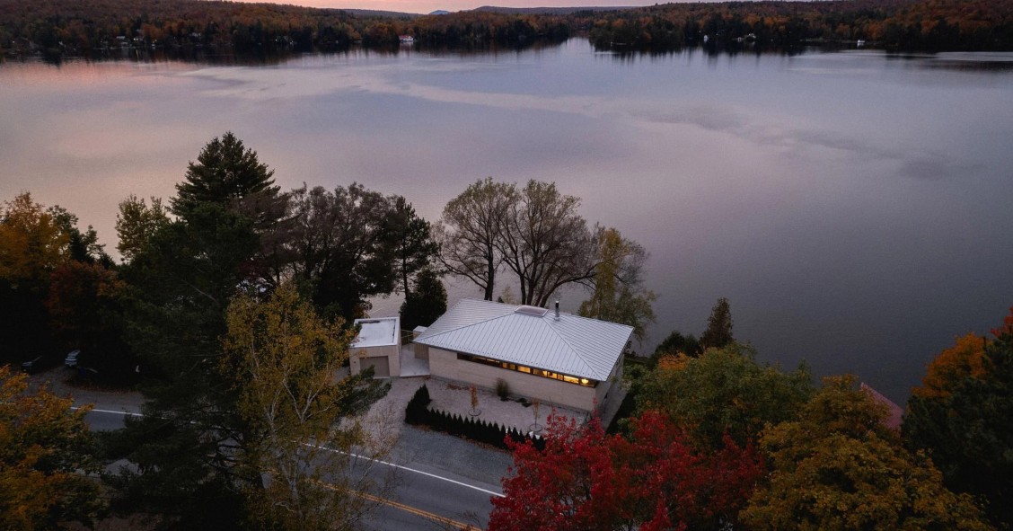 La vivienda, bautizada como Palissade y diseñada por Naturehumaine, se ubica entre una carretera y un lago en Quebec.