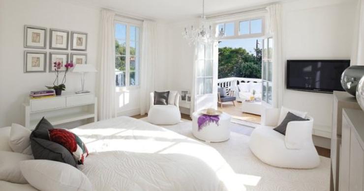 imagem de uma das modernas suites da casa com grandes janelões e varandas sobre o jardim casas de sonho: mansão eclética no selecto porto de saint tropez (frança)