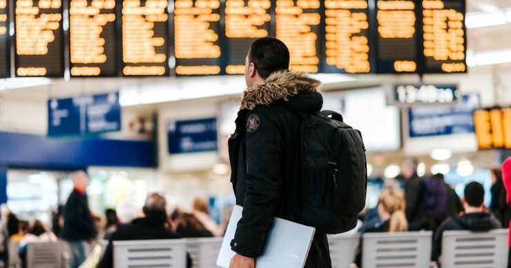 jovem com mochila em aeroporto