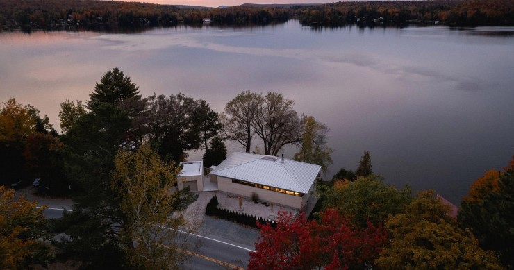 La vivienda, bautizada como Palissade y diseñada por Naturehumaine, se ubica entre una carretera y un lago en Quebec.