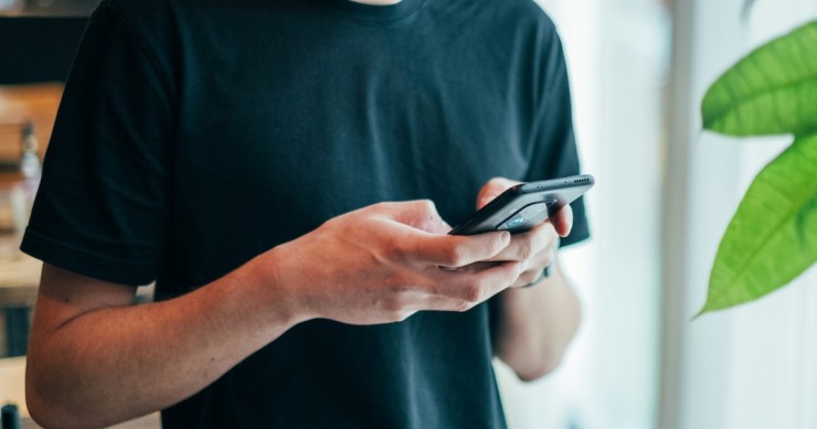 jovem a ver mensagem no telemóvel