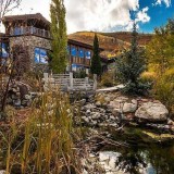 Casas de sonho: Mansão na montanha que passaria despercebida se não fosse o rio que atravessa a sala 