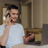 jovem contente ao telemóvel a ser alvo de burla